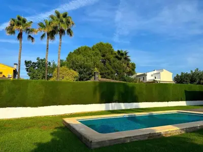 a swimming pool in a yard with palm trees at Casa Chalet Villa con piscina, jardín y aire acondicionado cerca de Valencia en La Eliana-L'Eliana in La Eliana