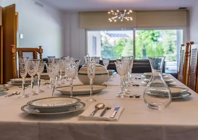 a table with glasses and plates and silverware on it at Casa Chalet Villa con piscina, jardín y aire acondicionado cerca de Valencia en La Eliana-L'Eliana in La Eliana