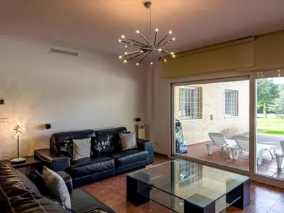 a living room with a couch and a glass table at Casa Chalet Villa con piscina, jardín y aire acondicionado cerca de Valencia en La Eliana-L'Eliana in La Eliana