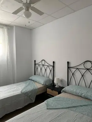 a bedroom with two beds and a ceiling fan at Apartamento Valencia 17 in Paiporta