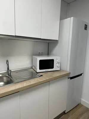 a white kitchen with a microwave and a sink at Apartamento Valencia 17 in Paiporta