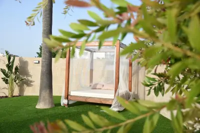 a hammock in a yard with a palm tree at Holiday Home Valencia in Riba-Roja De Turia