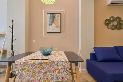 a dining room with a table and a blue chair at Buenos Aires Blues in Valencia