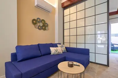 a blue couch in a living room with a table at Buenos Aires Blues in Valencia