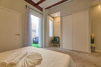 a bedroom with a large bed and a sliding door at Buenos Aires Blues in Valencia