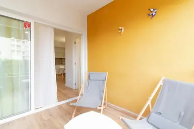 two blue chairs in a room with a yellow wall at Global Vacacional, Apartamento con piscina y terraza en Canet in Canet de Berenguer