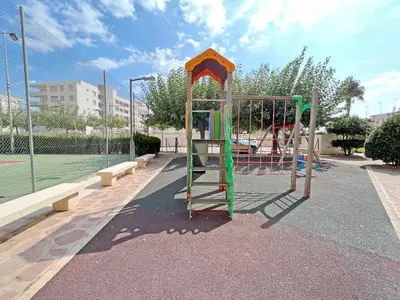 a park with a playground with a tennis court at Global Vacacional, Apartamento con piscina y terraza en Canet in Canet de Berenguer