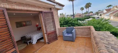 a balcony with a bed and a chair on a patio at Casa en la playa in Sagunto