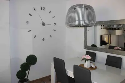 a large clock on a white wall in a room at Precioso apartamento con vistas al mar. Piscina. in Valencia
