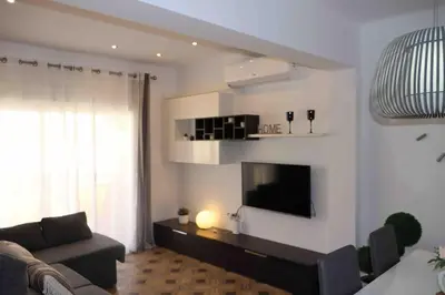 a living room with a couch and a flat screen tv at Precioso apartamento con vistas al mar. Piscina. in Valencia