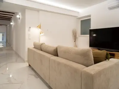 a living room with a couch and a flat screen tv at Central Market - Ciutat Vella, exclusively for families - Mid-term in Valencia