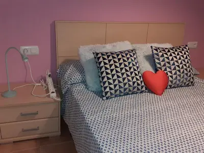 a bedroom with a bed with a heart on the pillows at Amanecer marino, solo a 5 minutos andando de la playa in Puzol