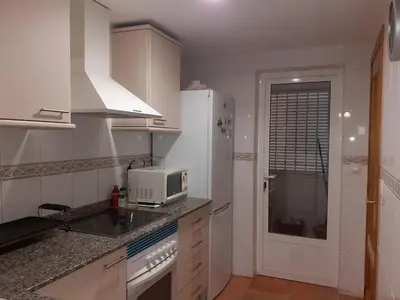 a white kitchen with a microwave and a sink at Amanecer marino, solo a 5 minutos andando de la playa in Puzol