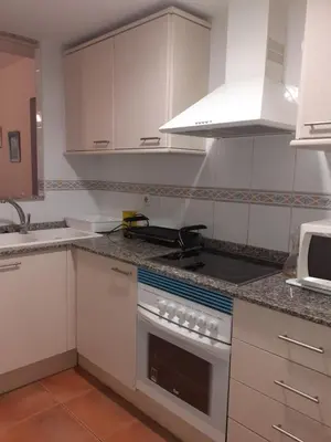 a kitchen with white cabinets and a stove top oven at Amanecer marino, solo a 5 minutos andando de la playa in Puzol
