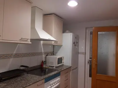 a white kitchen with a microwave and a sink at Amanecer marino, solo a 5 minutos andando de la playa in Puzol