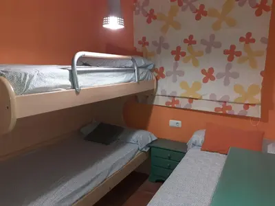 a small room with two bunk beds and a table at Amanecer marino, solo a 5 minutos andando de la playa in Puzol