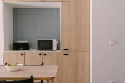 a kitchen with wooden cabinets and a table at La Alfarería in Valencia