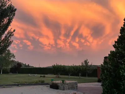 a cloudy sky over a park at sunset at La Traviesa,Villa de Lujo de 500 m. en el Campo con Piscina in Campo Arcís
