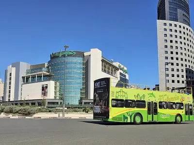 a yellow and green bus parked in front of buildings at Apartamentos Las Ciencias Studio Q in Valencia