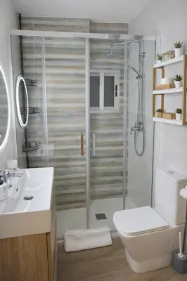 a bathroom with a shower and a toilet and a sink at Bonito apartamento con vistas al mar in Playa Pobla de Farnals