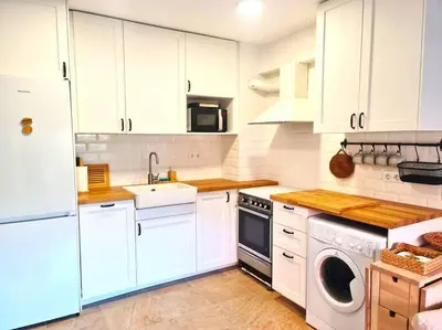a kitchen with white cabinets and a washer and dryer at Bonito apartamento con vistas al mar in Playa Pobla de Farnals