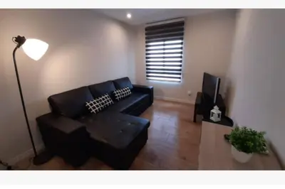 a living room with a black couch and a television at Apartamento WELCOME céntrico de diseño en calle Tres Forques in Valencia
