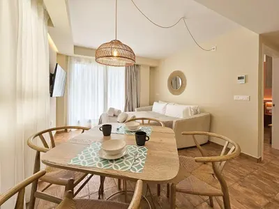 a living room with a table and chairs and a couch at Apartamentos Las Ciencias R in Valencia