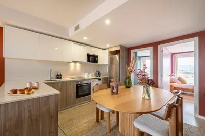 a kitchen with a table and a dining room at Gran Canet 2BR! Walk to Beach, Sea View, Sauna & Gym in Canet de Berenguer