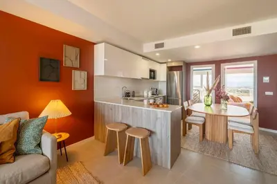 a kitchen and living room with a table and a couch at Gran Canet 2BR! Walk to Beach, Sea View, Sauna & Gym in Canet de Berenguer