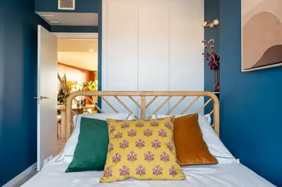 a bedroom with blue walls and a bed with a pillow at Gran Canet 2BR! Walk to Beach, Sea View, Sauna & Gym in Canet de Berenguer