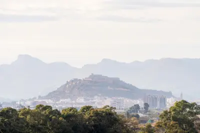 a view of a city with mountains in the background at Gran Canet 2BR! Walk to Beach, Sea View, Sauna & Gym in Canet de Berenguer
