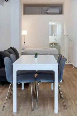 a white dining room table with blue chairs and a bed at VLC HOST- Fray Pedro in Valencia
