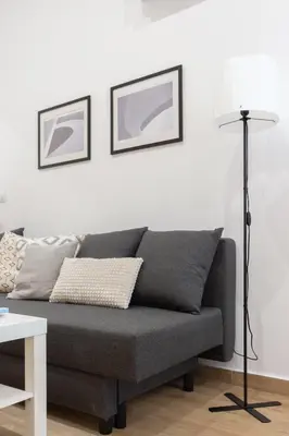 a living room with a gray couch and a lamp at VLC HOST- Fray Pedro in Valencia