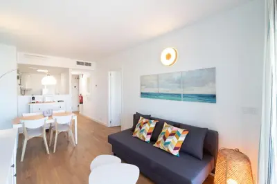 a living room with a couch and a table at Global Vacacional, Moderno apartamento con piscina en la playa de Canet in Canet de Berenguer