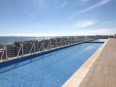a swimming pool on the roof of a building at Global Vacacional, Moderno apartamento con piscina en la playa de Canet in Canet de Berenguer