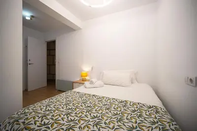 a bedroom with a large bed in a white room at Casa Ross en Ruzafa in Valencia