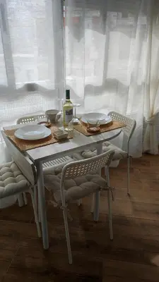 a white table with chairs and a bottle of wine at Apartament CullerA in Cullera