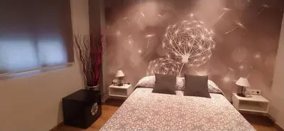 a bedroom with a bed with a flower wall at Hostal Happystay in Valencia