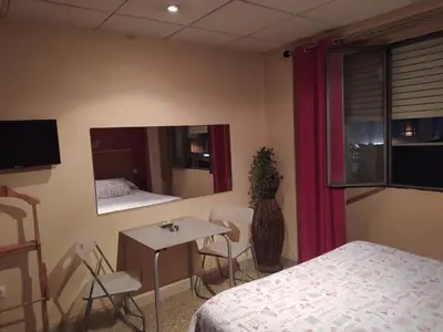 a room with a bed and a table and a mirror at Hostal Happystay in Valencia