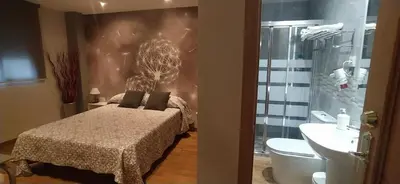 a bedroom with a bed and a toilet and a sink at Hostal Happystay in Valencia