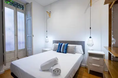 a bedroom with a large white bed with towels on it at FLORIT FLATS - The Vella Apartment in Valencia