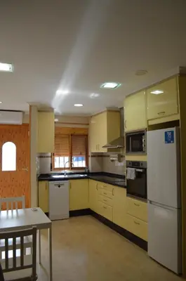 a kitchen with yellow cabinets and a white refrigerator at Barraca Beach in Valencia