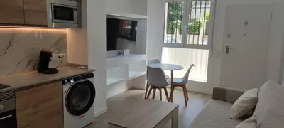 a kitchen and living room with a washing machine and a table at Precioso apartamento de diseño para 4-6 personas VT-55212-V in Valencia