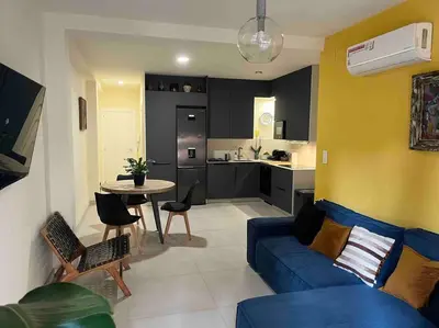 a living room with a blue couch and a kitchen at Modern apartment in heart of city in Valencia