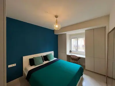 a blue bedroom with a bed with a blue wall at Modern apartment in heart of city in Valencia