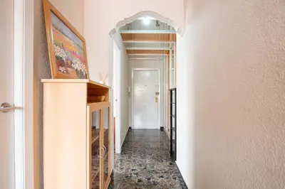 a hallway leading to a room with white walls and a hallway at Apartamento en complejo residencial con piscina y garaje a 100m del mar in Las Canteras