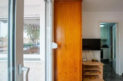 a door leading into a room with a desk and a television at Apartamento en complejo residencial con piscina y garaje a 100m del mar in Las Canteras