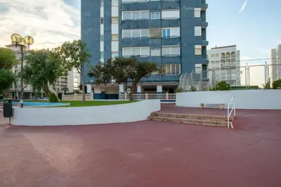 a park with a bench in front of a building at Apartamento en complejo residencial con piscina y garaje a 100m del mar in Las Canteras