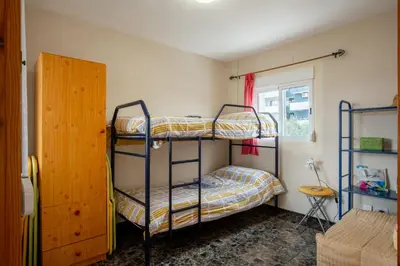 a bedroom with two bunk beds and a window at Apartamento en complejo residencial con piscina y garaje a 100m del mar in Las Canteras