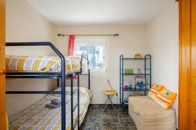 a room with two bunk beds and a couch at Apartamento en complejo residencial con piscina y garaje a 100m del mar in Las Canteras